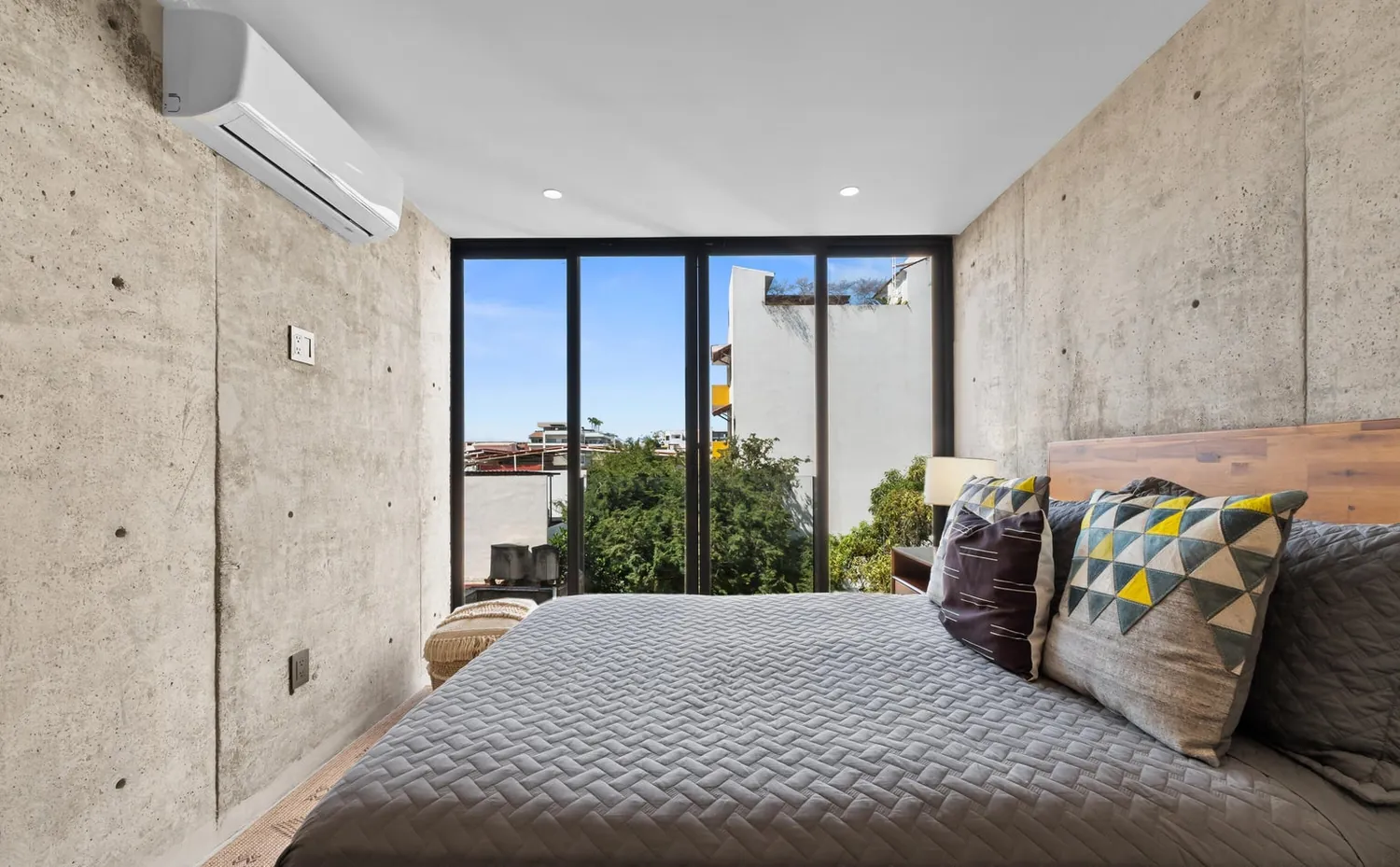 The second bedroom, framed by floor-to-ceiling glass