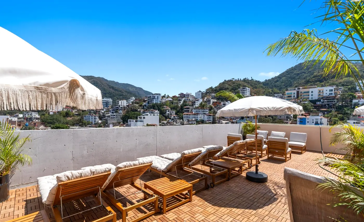 Rooftop sun loungers and umbrellas with a mountain view