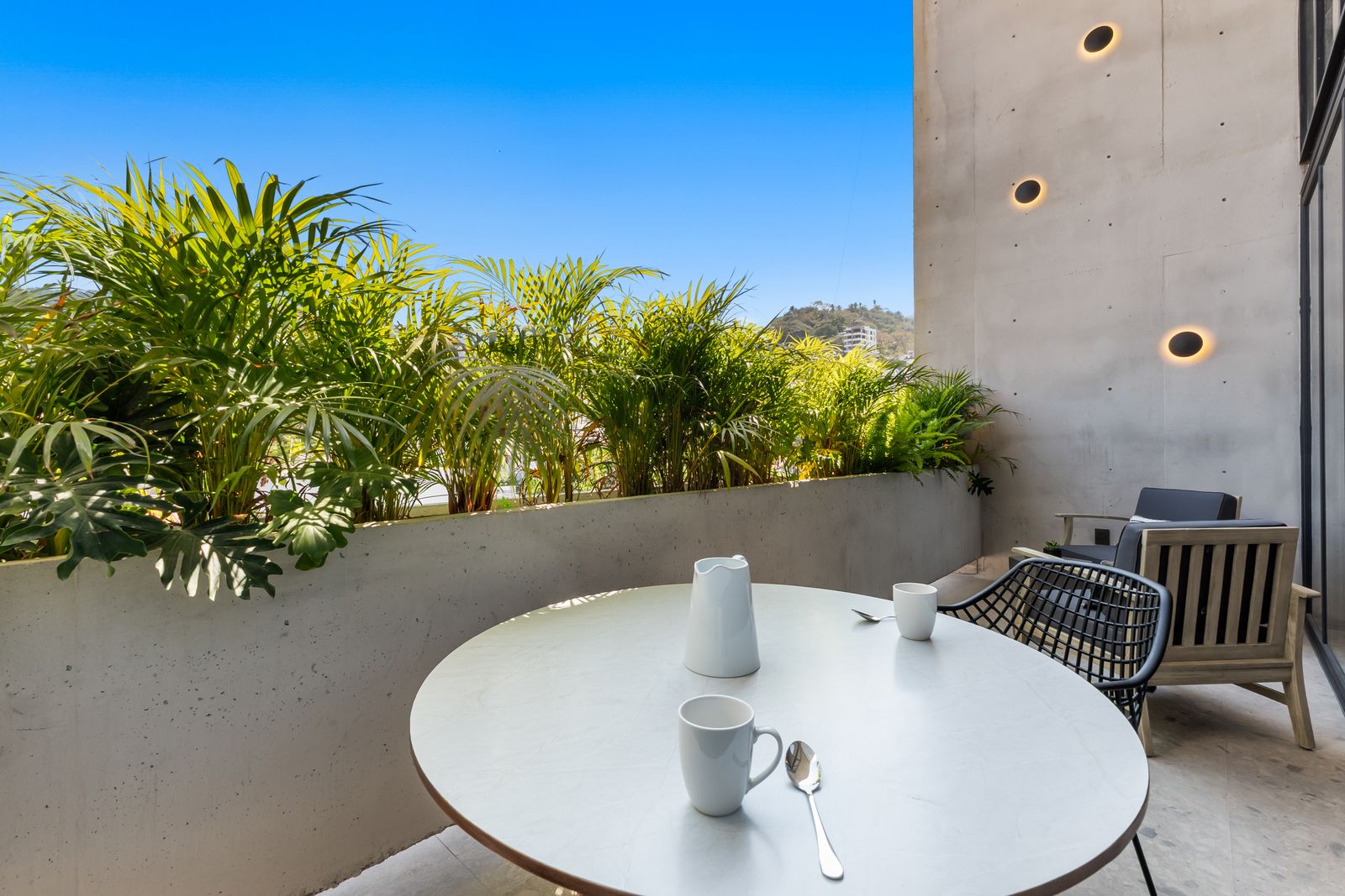 Private terrace breakfast with greenery and mountain backdrop